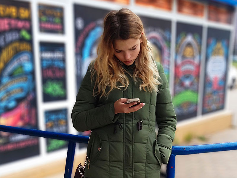 A woman who's feeling ignored by her boyfriend, looking at her phone and trying to figure out what to do when he ignores you.