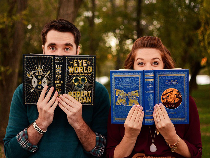A nerdy couple reading books together.