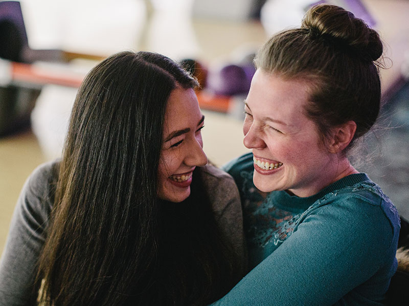 A bisexual woman who often deals with biophobia laughing with another woman she's on a date with.