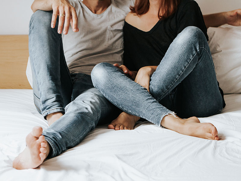 A couple with no trust in their relationship, sitting in bed together having a conversation about it.
