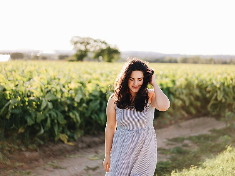 A woman who's letting go of love, walking in a field and reflecting on her time alone.