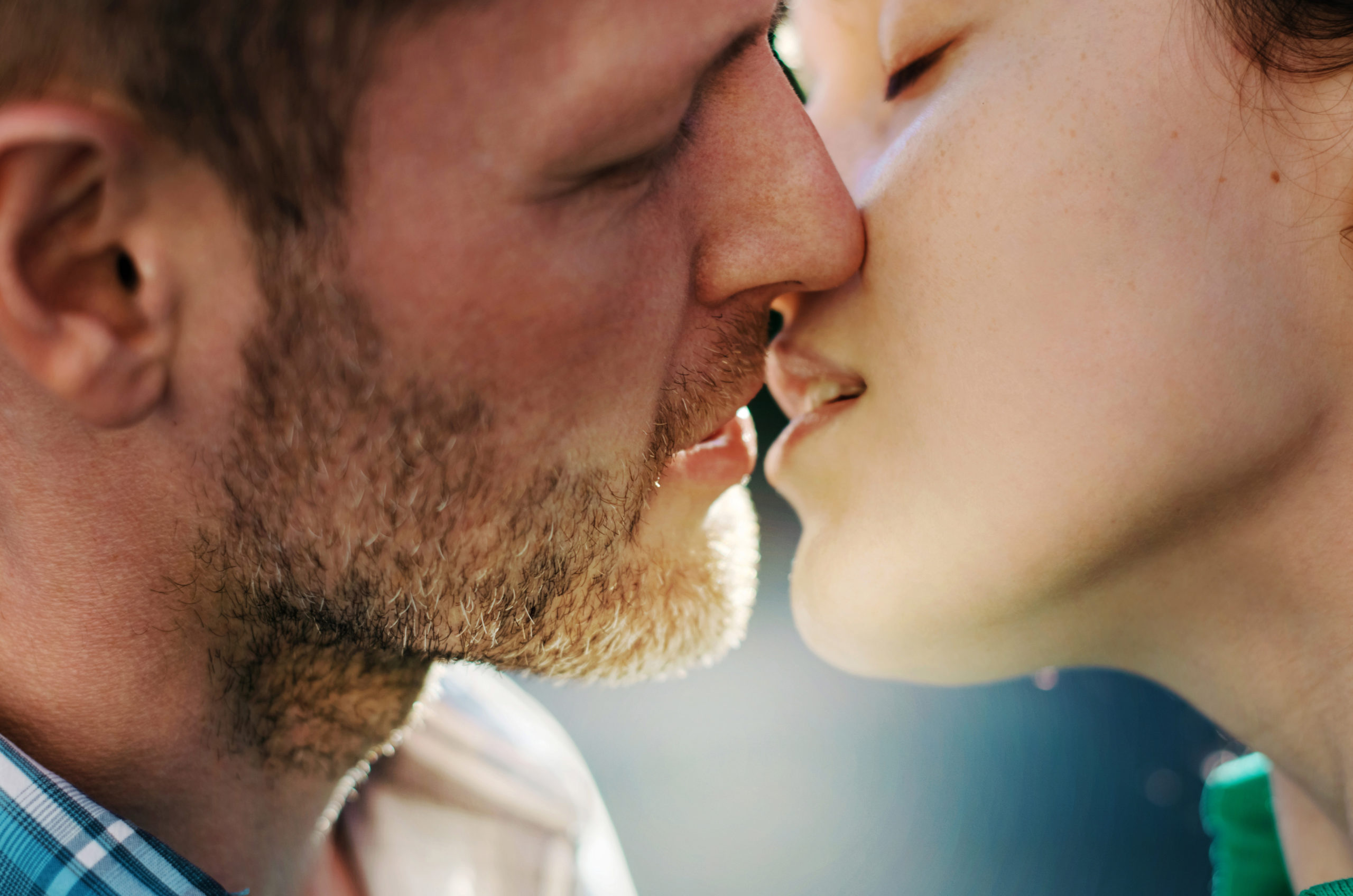 Close-up image of romantic couple leaning in for a kiss while figuring out the difference between infatuation vs. love.