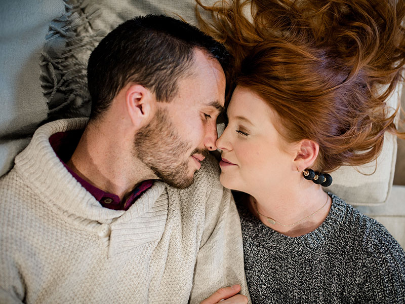 A couple cuddling and touching noses during cuffing season.