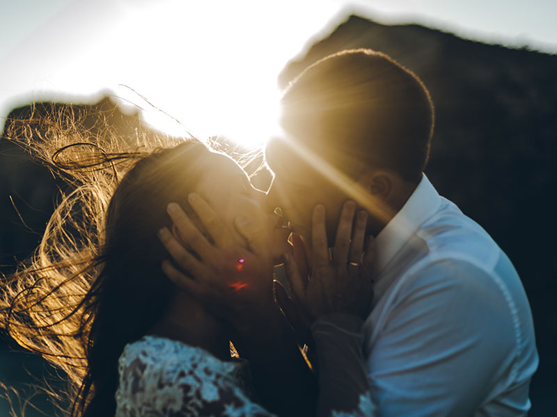 A couple who used these I love you because examples kissing at sunset.