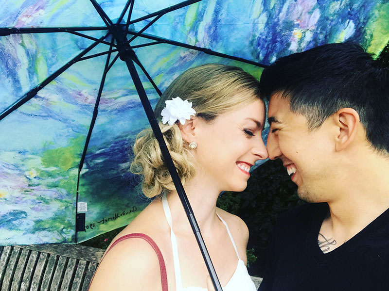 A couple who had good couple goals, under an umbrella together cuddling.