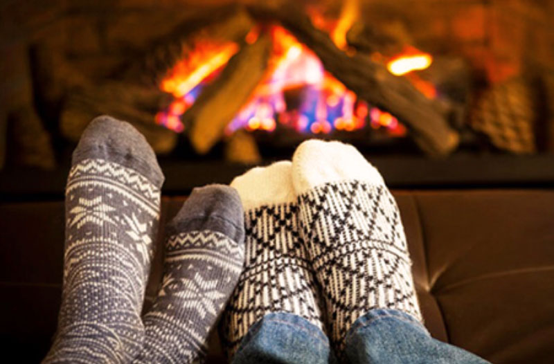 A couple by the fire snuggled up and having a great time on this winter date ideas.