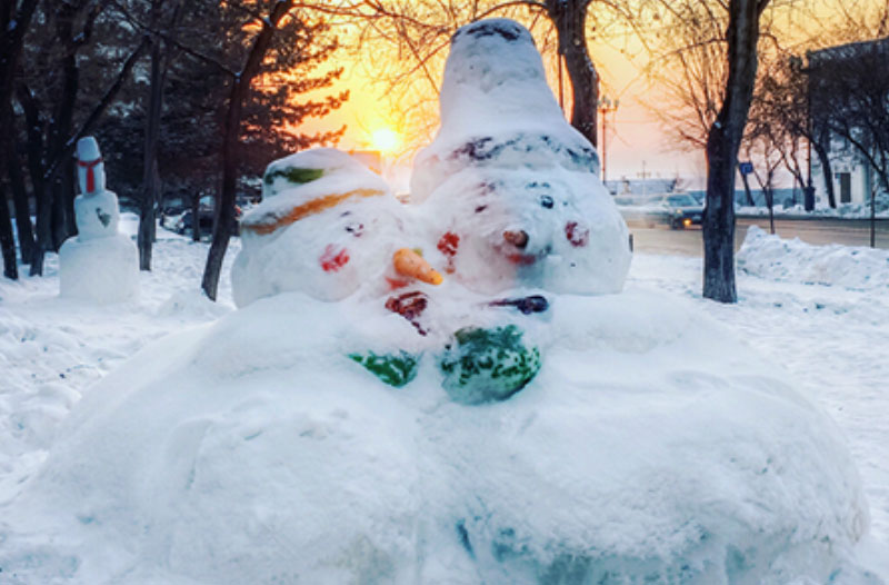 A couple of snowmen cuddling in the snow, since a couple took this winter date idea and decided to play.