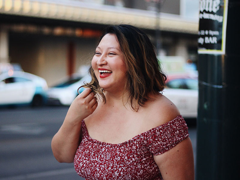 A woman laughing and smiling as she gets over a heartbreak.