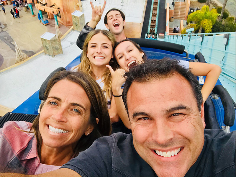 Single parents who date each other on a roller coaster with their kids.