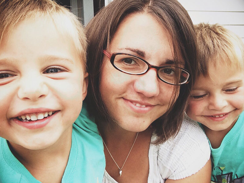A woman who knows all about these tips for dating a single mom smiling with her two sons in her backyard.