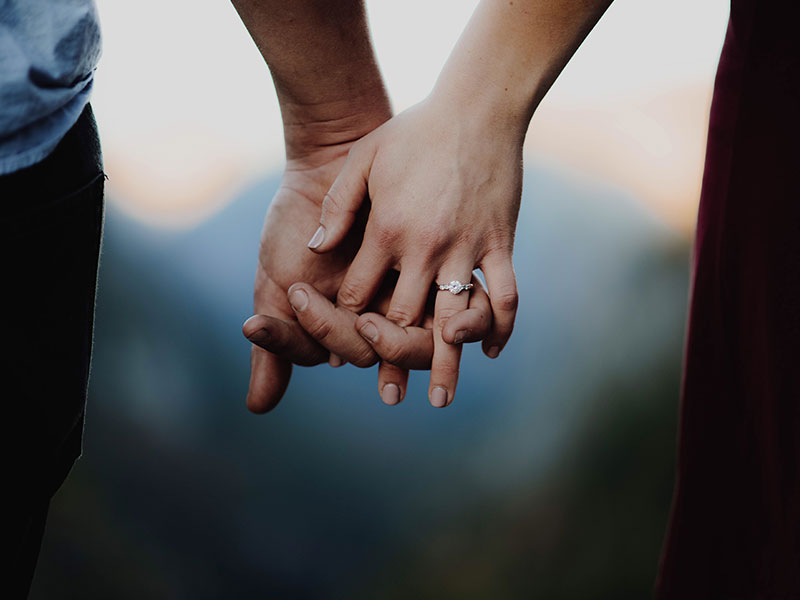 An engaged couple holding hands, ready to get pressure from their family.