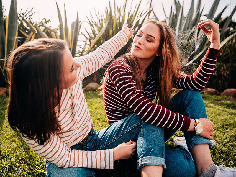 A girl who's in a one-sided friendship talking to her friend who isn't paying much attention.