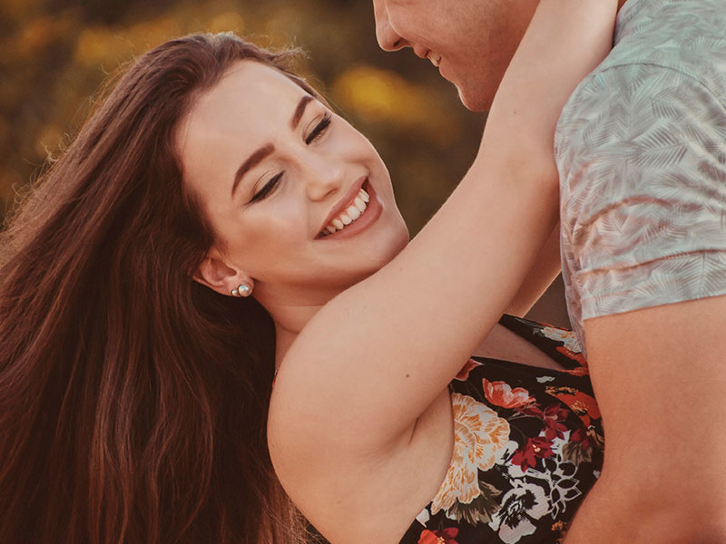 A woman who's always with unavailable men, hugging her boyfriend who's not paying attention to her.