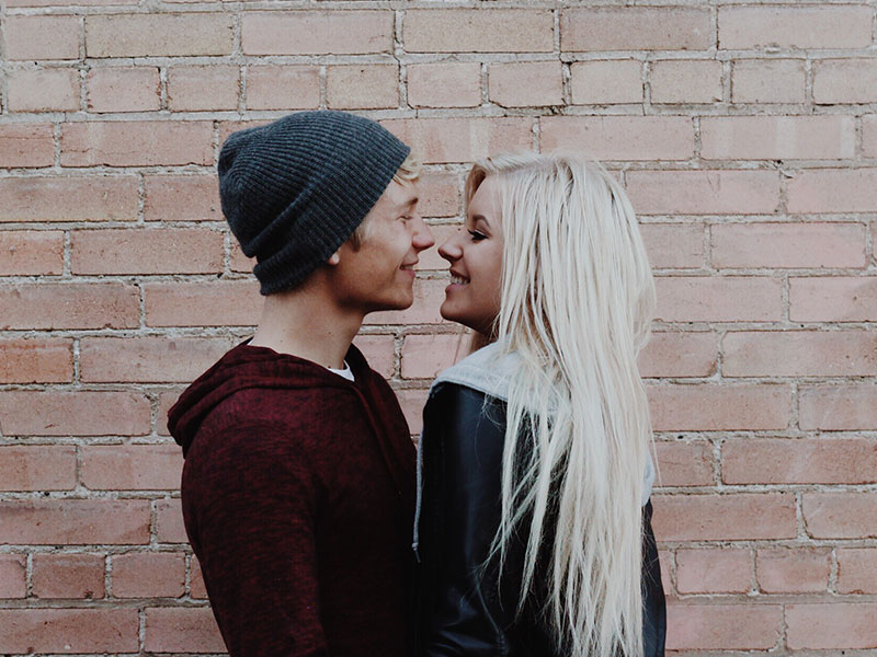 A couple on a first Tinder date, looking at each other in the eyes, about to kiss.