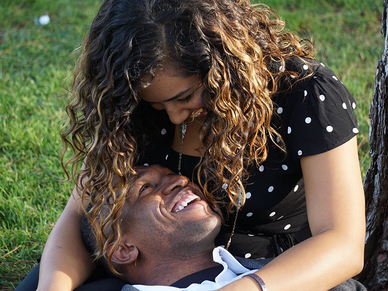 A couple talking and active listening while sitting in the grass.