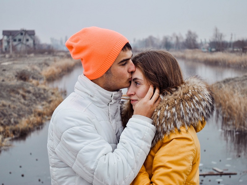 A couple sharing a tender forehead kiss, symbolizing affection and deep connection in relationships on Zoosk.