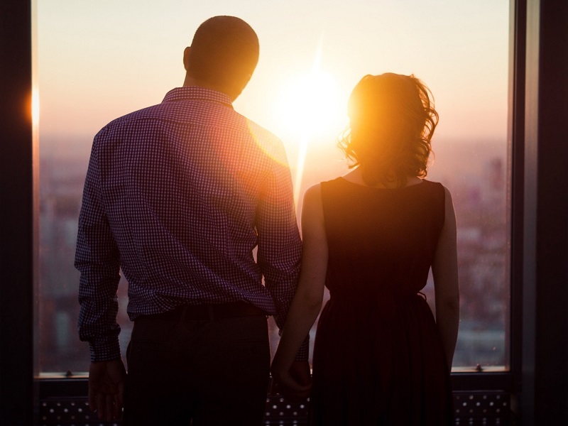 couple holding hands, looking out window and demonstrating characteristics of a healthy relationship