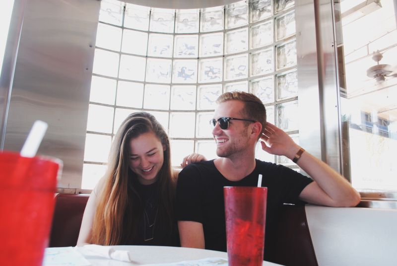 woman practising how to flirt with a guy she likes in a restaurant