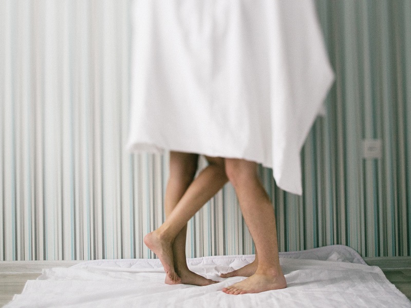couple standing behind white towel trying out ways how to spice up your sex life