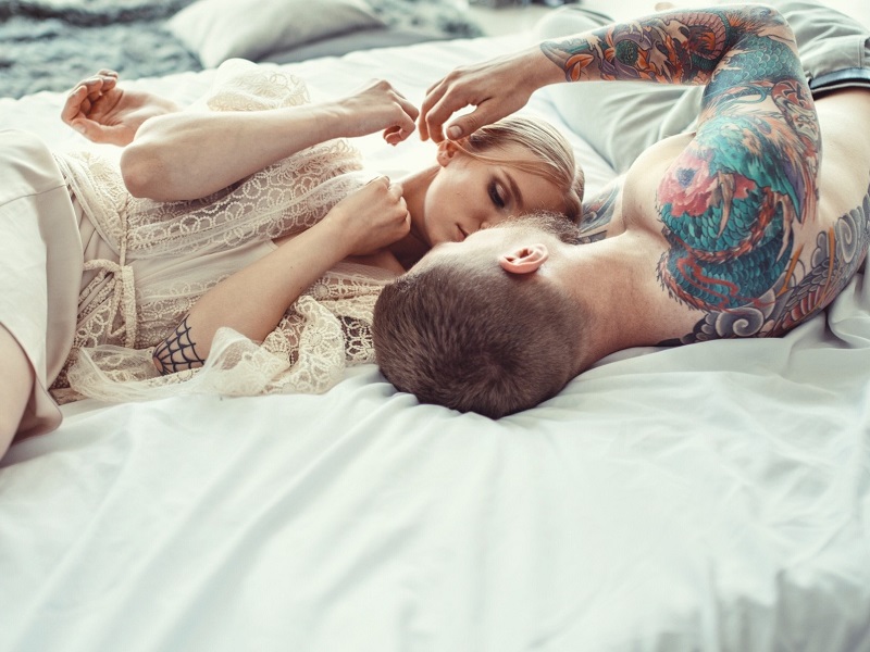 Couple lying on bed discussing intimacy issues