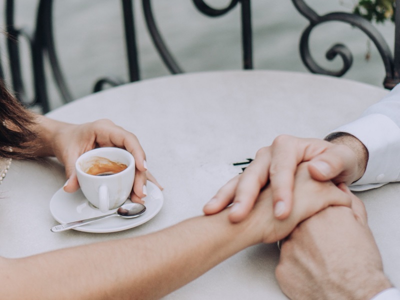 couple holding hands at cafe talking about trust issues in a relationship
