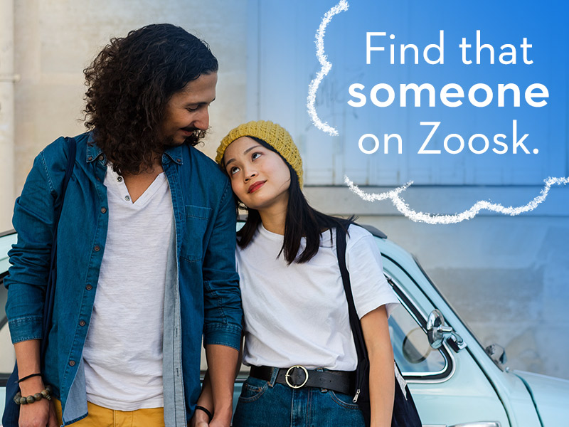 Cute couple holding hands and looking at each other explaining what is Zoosk