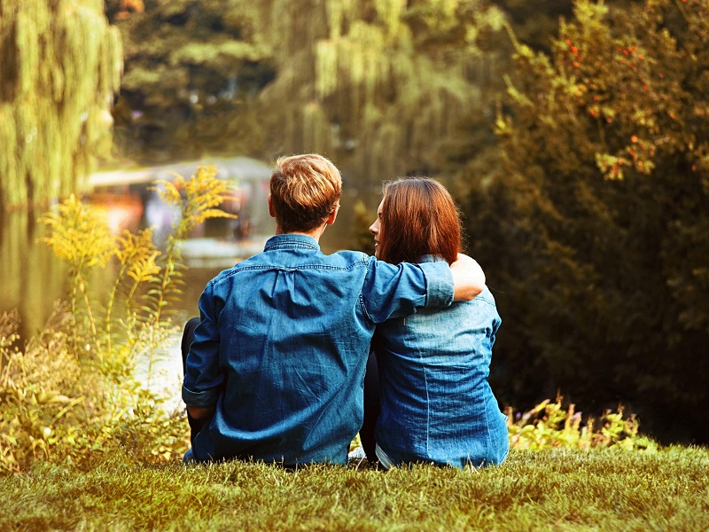 cute couple sitting in park discussing new relationship quotes