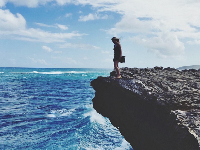 woman on cliff edge considering