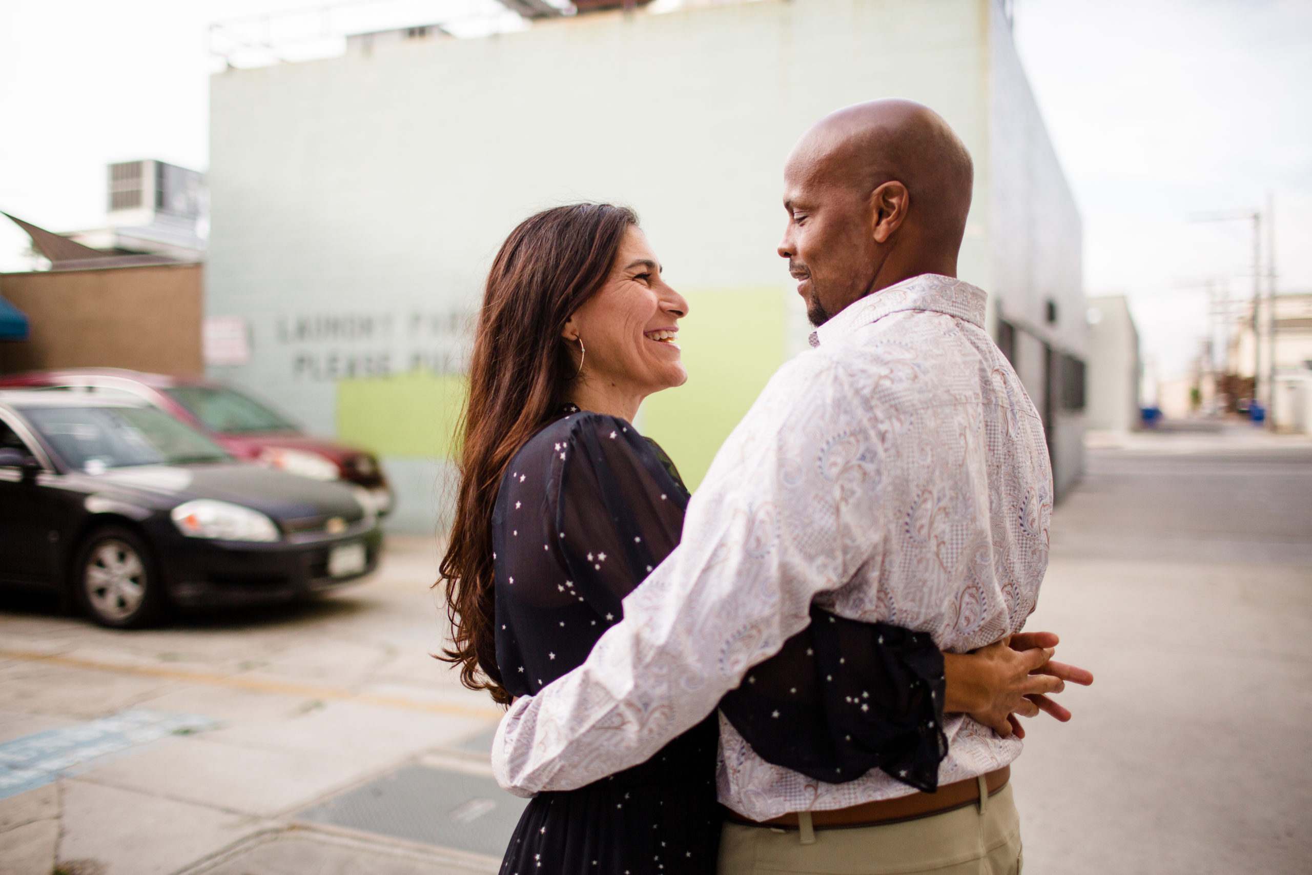 Happy couple standing outdoors and embracing each other while smiling and working out how to date after a divorce.