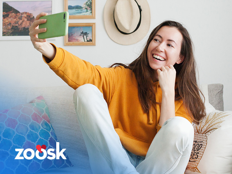 attractive woman on safe taking a selfie for her Zoosk profile