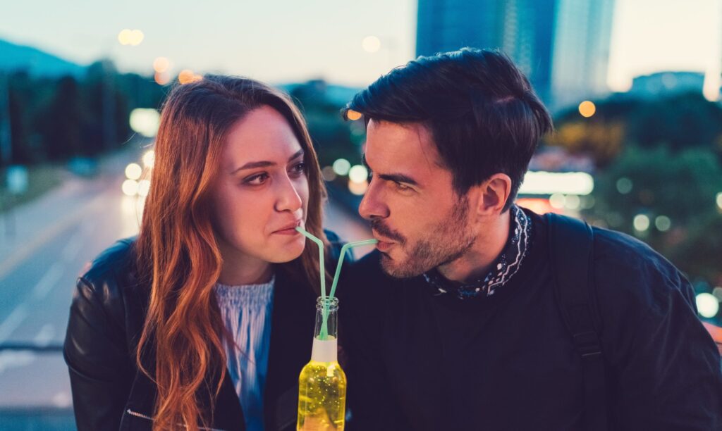 happy single man and woman on a date sharing a soda