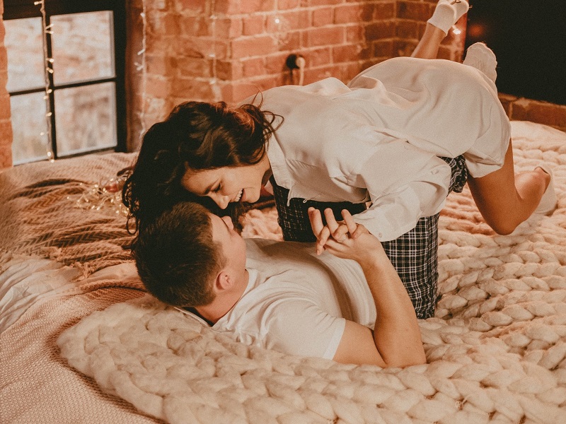 couple laughing and making out in bed