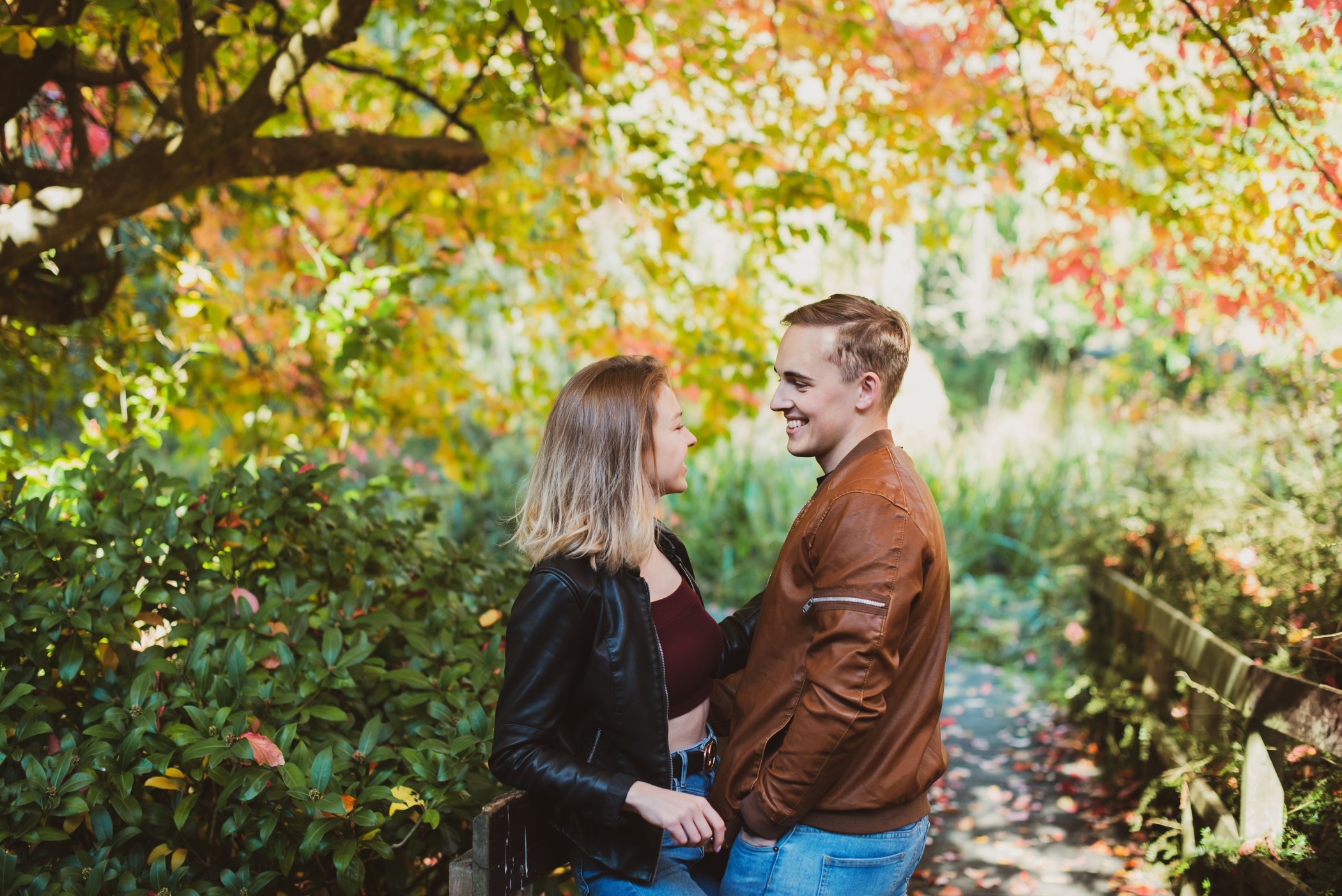couple laughing while on walk in park in Autumn