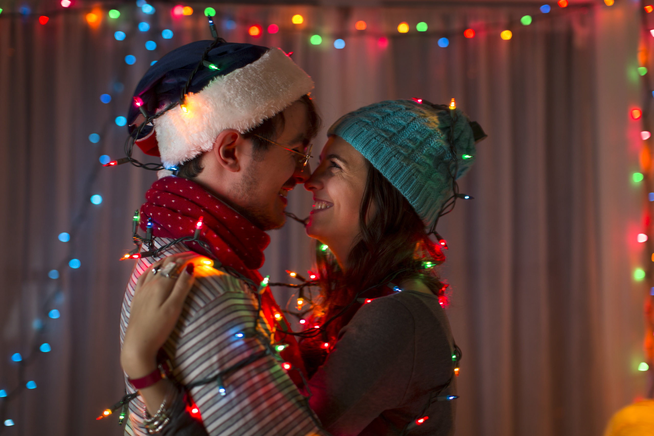 Happy couple smiling and embracing each other while balancing their sex and family life around the holidays.