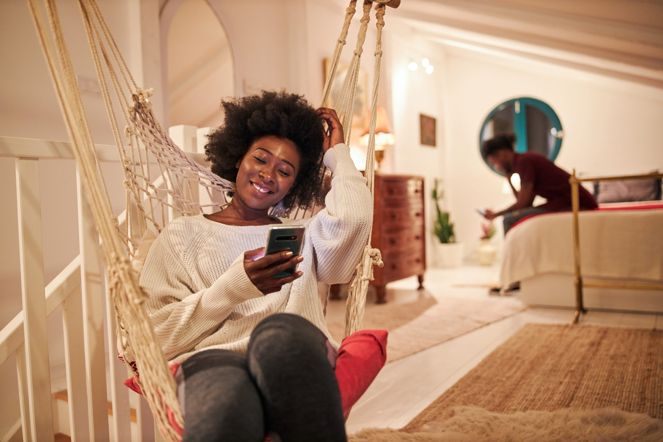 Happy woman video dating on mobile phone and smiling after learning how to FaceTime your crush.