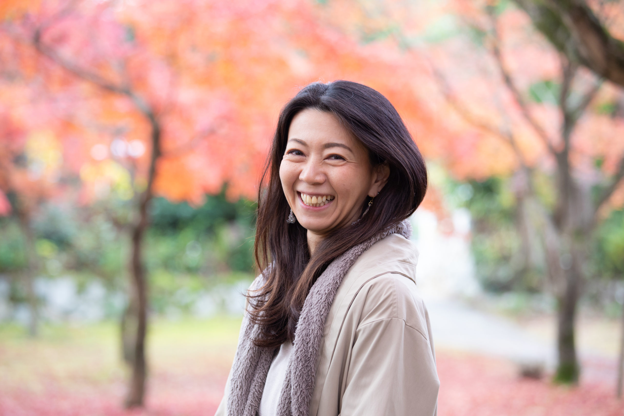 Happy woman standing outdoors, looking towards the camera and smiling while practicing self-care after a breakup.